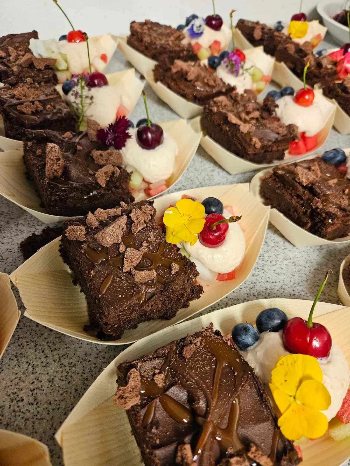 Brownies med flødeskum og friske bær serveret i små skåle